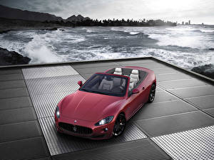 Фотография Мазерати Maserati GranCabrio у моря на подиуме машины