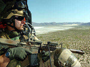 Фотография Солдаты Десант смотрит на пустыню сидя с автоматом в вертолете
